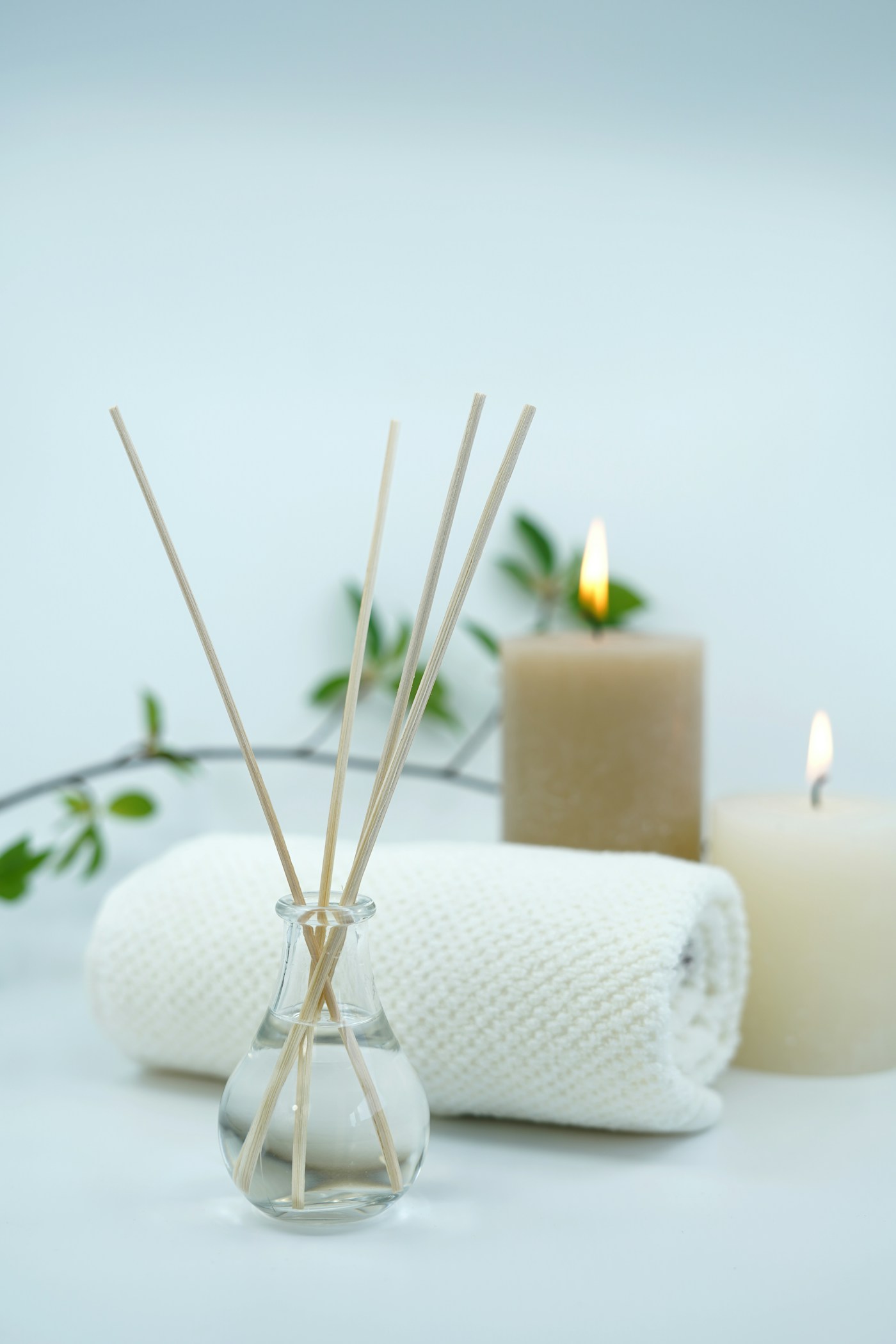 Diffuseur, serviette et bougies sur un fond clair, photographie d’illustration